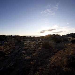 Desert Sunset Over Scrubland and Distant Community