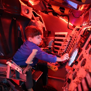 Young Astronaut Explores Space Capsule Interior at Museum