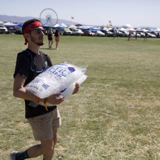 A man carrying a large bag of ice to beat the heat