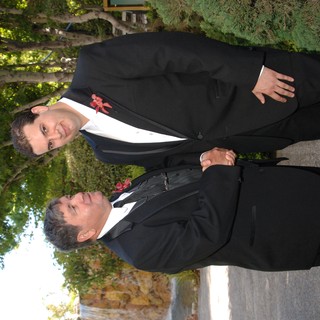 Two Men in Tuxedos Share a Handshake at Wedding