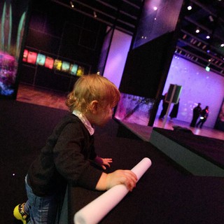 Child Exploring Interactive Light Installation at Museum