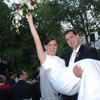 Jubilant Bride Carried by Groom After Outdoor Ceremony