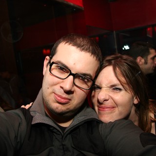 Friends Pose Together at Dimly Lit Night Venue