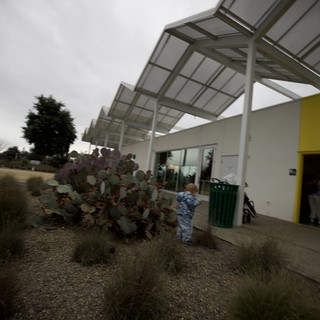 Child Playing Near Modern Solar Canopy Structure