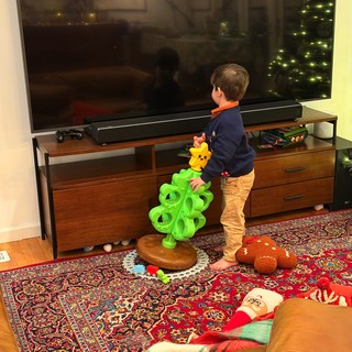 Young Child Playing with Bright Green Toy in Living Room