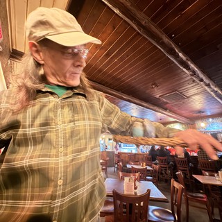 Long-Haired Patron Gesturing in Santa Fe Restaurant