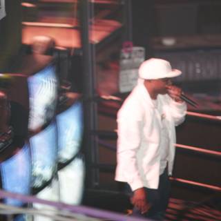 Man in White Jacket and Hat on Stage
