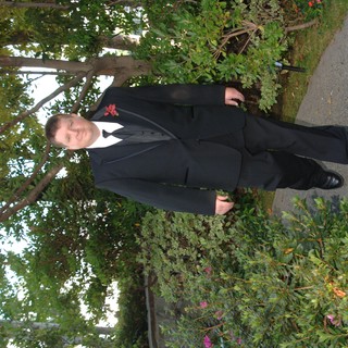 Dapper Groomsman Walks Garden Path at Wedding