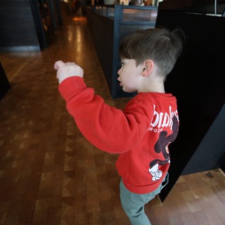 Young Boy Exploring Museum Exhibition in Red Hoodie