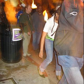 Man Walking Down Street with Fire in Hand