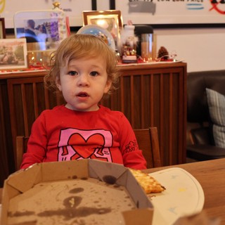 Toddler Enjoying Pizza at Christmas Dinner Table