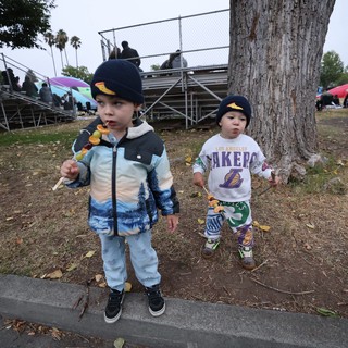Two Young Boys Enjoying Candy Skewers at Balloon Festival