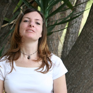 Woman Smiling Serenely Beneath Tropical Trees