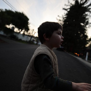 Young Boy on Skateboard at Dusk in Suburban Street