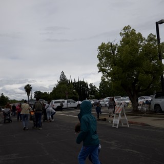 Child in Turquoise Hoodie at Community Gathering
