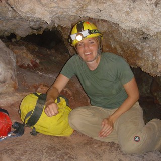 Underground Explorer Poses in Limestone Cave Passage