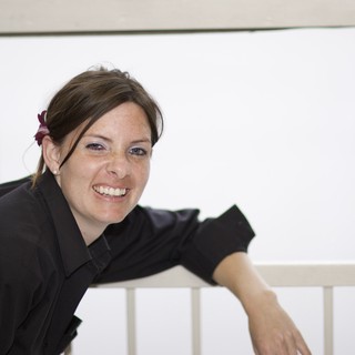 Smiling Woman Leaning on White Railing Outdoors