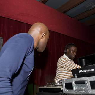 Two Men Entertain the Crowd at a DJ Booth