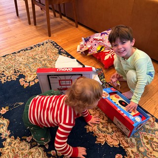 Brothers Playing with Toy Cash Register on Living Room Floor