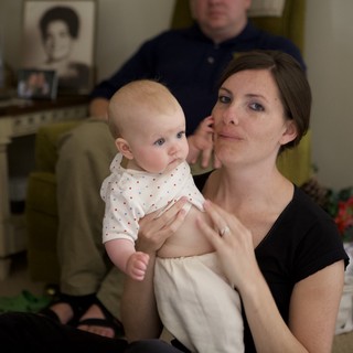 Mother Holding Infant at Family Gathering Indoors