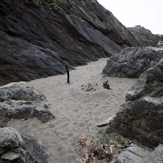 Secluded Rocky Cove With Remnants of Beach Campfire