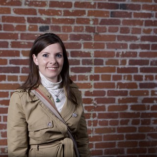 Young Woman Smiling Against Rustic Brick Wall