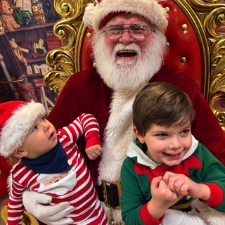 Two Children Visit Santa in His Festive Workshop
