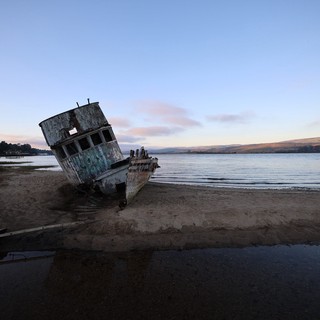 Abandoned Shipwreck at Twilight on Coastal Beach
