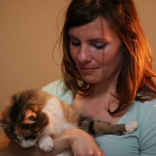 Woman Cradling Sleeping Calico Kitten Tenderly