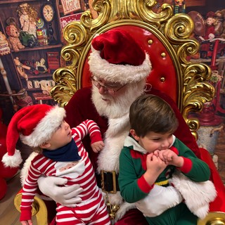 Two Children Visit Santa in His Toy Workshop