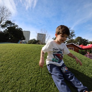 Joyful Child Running Barefoot on Sunny Park Hill