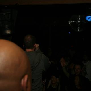 Partygoer stands under the disco ball at a dark nightclub