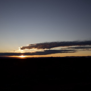 Dramatic Sunset Over Dark Desert Landscape