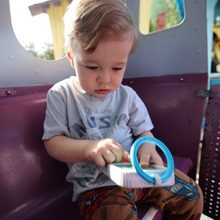 Toddler Playing with Toy at Colorful Playground