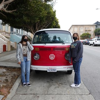 Friends Pose with Classic Red Volkswagen Bus