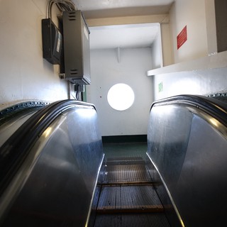 Descending Escalator into Industrial White Corridor