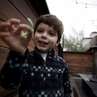 Young Boy Reaching Toward Camera on Outdoor Patio