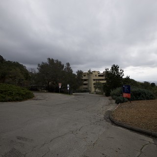 Overcast Hillside Road Leading to Multi-Story Building