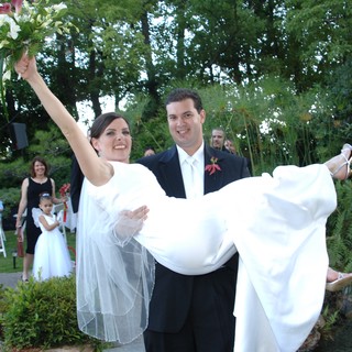 Groom Carries Jubilant Bride After Outdoor Garden Wedding