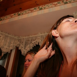 Woman Tilts Head Back at Indoor Gathering