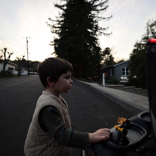 Boy with Toy Car on Suburban Street at Dusk