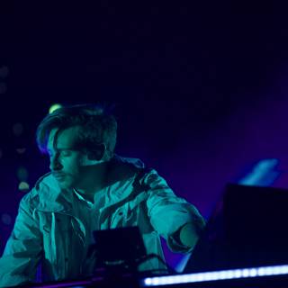 Flume in Concert Caption: Australian deejay Flume entertains the crowd at Coachella 2016, playing his keyboard and laptop while wearing a white jacket in the midst of an electric lighting and visual display on stage.