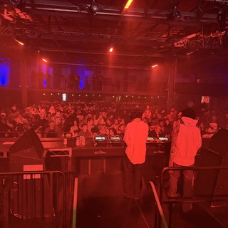 DJ Performance at Electronic Music Venue Under Red Stage Lights