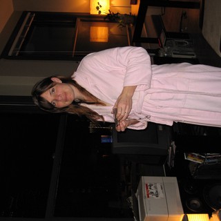 Woman in Pink Robe Standing in Dimly Lit Apartment