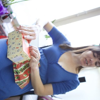 Reindeer-Antlered Woman Unwrapping Christmas Gift Joyfully