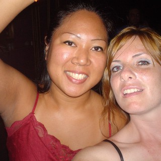 Two Friends Smiling Together at a Nighttime Event