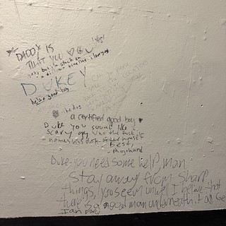 Handwritten Wall Messages in a Bathroom Stall