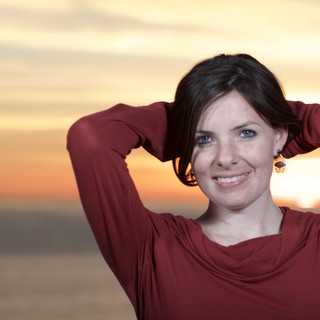 Radiant Woman Smiling at Sunset by the Sea