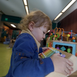 Young Child Exploring Educational Toys in Play Space