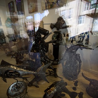 Metal Sculptures Displayed Behind Gallery Window Reflections